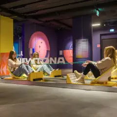 Dwie dziewczyny na wózkach w muzeum grawitacji, eksperymentują z liną.