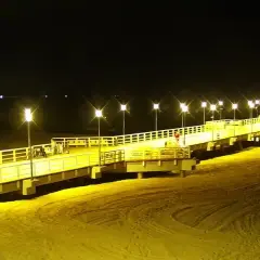Nocne Jelitkowo: oświetlony molo, plaża i morze. Atrakcje turystyczne w blasku latarni.