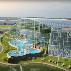 Nowoczesny park wodny pod Warszawą z basenami i palmami pod szklaną kopułą.