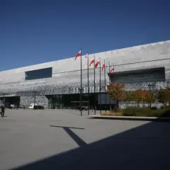 Nowoczesne muzeum historii Polski otwarcie. Flagi biało-czerwone powiewają przed budynkiem.