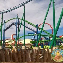 Tor RMF Dragon Roller Coaster, z zielonymi i niebieskimi torami, zapowiada ekscytującą jazdę i maksymalną prędkość.