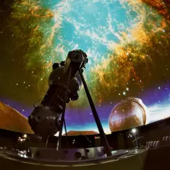 Wielki projektor gwiazd w centrum, otoczony siedzeniami, tworzy magiczne planetarium dla dzieci.