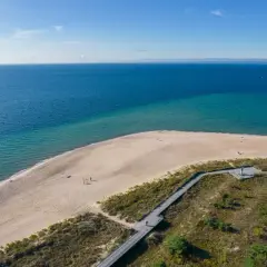 Piękna plaża i morze na Helu. Warto zobaczyć to miejsce, gdzie drewniana kładka prowadzi przez wydmy do piaszczystego brzegu.