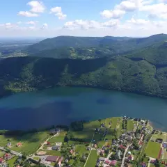 Widok z lotu ptaka na Jezioro Międzybrodzkie z malowniczą plażą i otaczającymi je zielonymi wzgórzami.