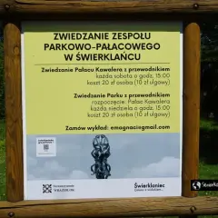 Tablica informacyjna o zwiedzaniu zespołu parkowo-pałacowego w Świerklańcu. Informacje o zwiedzaniu pałacu i parku z przewodnikiem, kosztach i godzinach.