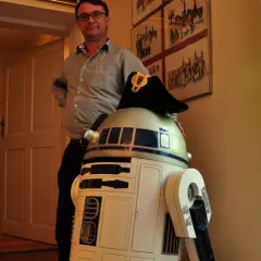 W muzeum Star Wars R2-D2 w wojskowym kapeluszu pozuje z mężczyzną.