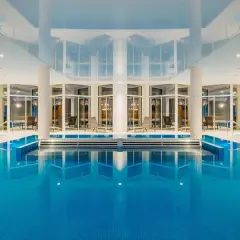 Wnętrze aquaparku Crystal Mountain z basenem, jacuzzi i leżakami.