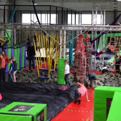 Wesoła zabawa w parku rozrywki Flysky! Dzieci skaczą, wspinają się i pokonują przeszkody na trampolinach i w basenie z gąbkami.