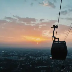 Kolejka linowa nad miastem o zachodzie słońca. Widok z gondoli, jakby polinka Wrocław wznosiła się ku niebu.