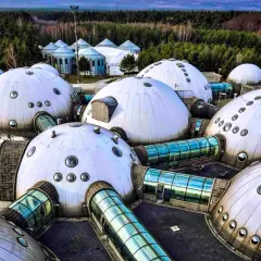 Alvernia Planet zwiedzanie: futurystyczne kopuły i szklane tunele w otoczeniu lasu.