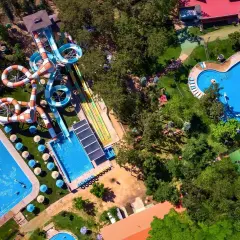 Widok z lotu ptaka na Santiago Aquapark: kolorowe zjeżdżalnie, baseny i zielone tereny rekreacyjne.