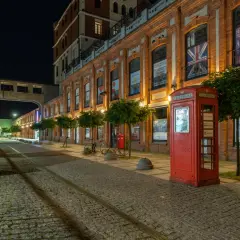 Nocny Żyrardów zachwyca. Czerwona budka telefoniczna i brukowana ulica tworzą niepowtarzalny klimat. To jedne z wielu żyrardowskich atrakcji.