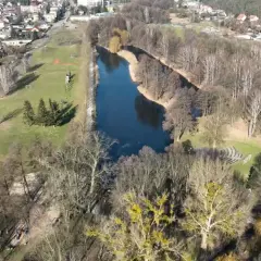 Widok z lotu ptaka na park drogowskazów w Witnicy. Jezioro, boisko, korty tenisowe i zabudowania mieszkalne.