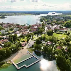 Malownicze miasteczko nad jeziorem, z plażą i basenem kąpielowym. Ryn oferuje wiele atrakcji, idealne miejsce na wypoczynek.