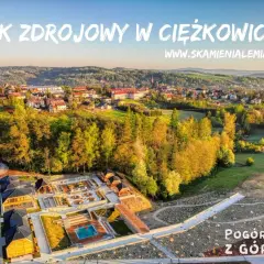 Park Zdrojowy w Ciężkowicach oferuje liczne atrakcje: plac zabaw, basen, sauny i ścieżki spacerowe. Widok z góry na malownicze Pogórze.