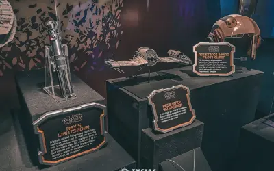 Miecz świetlny Rey, hełm pilota A-winga i pojazd Resistance Ski Speeder z wystawy Star Wars Galaxy's Edge.