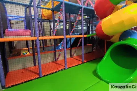 Kolorowy plac zabaw w parku rozrywki Koszalin z rurami, zjeżdżalniami i basenem z kulkami.