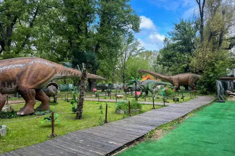 Spacer po parku z dinozaurami w Warszawie. Gigantyczne modele prehistorycznych stworzeń wśród zieleni i drewnianych ścieżek.
