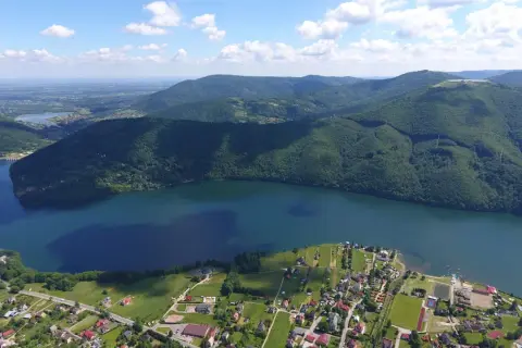 Widok z lotu ptaka na Jezioro Międzybrodzkie z malowniczą plażą i otaczającymi je zielonymi wzgórzami.