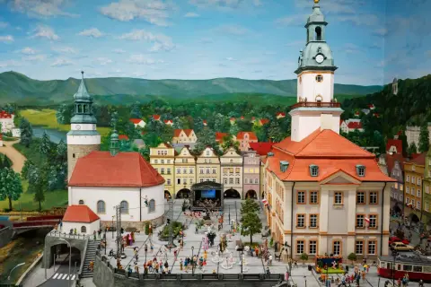 Miniaturowa kolejkowo scena z Jeleniej Góry, z ratuszem, kościołem i tłumem ludzi na rynku.