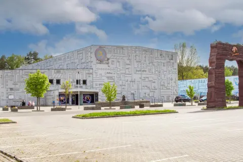 Fasada budynku z motywem labiryntu, symbolizująca park nauki i ewolucji człowieka. Obok monumentalny łuk.