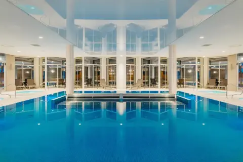 Wnętrze aquaparku Crystal Mountain z basenem, jacuzzi i leżakami.