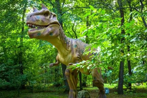 Witaj w parku ruchomych dinozaurów! Gigantyczny, realistyczny T-Rex czeka na Ciebie wśród bujnej zieleni.