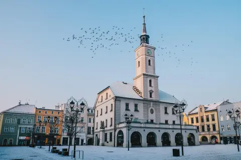 Ratusz w Gliwicach zimową porą, z ptakami na niebie. Wspaniałe gliwice atrakcje, które warto zobaczyć.