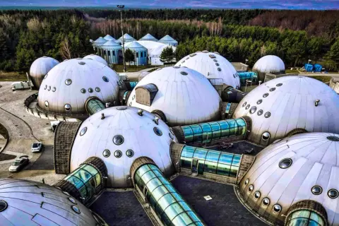 Alvernia Planet zwiedzanie: futurystyczne kopuły i szklane tunele w otoczeniu lasu.