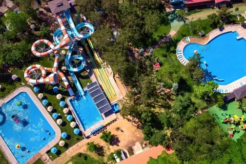 Widok z lotu ptaka na Santiago Aquapark: kolorowe zjeżdżalnie, baseny i zielone tereny rekreacyjne.