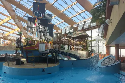 Wesoły aquapark w Czechach z pirackim statkiem, zjeżdżalniami i wodospadem. Idealne miejsce na rodzinną zabawę.