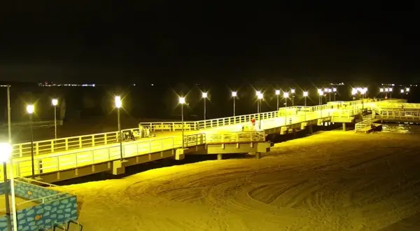 Nocne Jelitkowo: oświetlony molo, plaża i morze. Atrakcje turystyczne w blasku latarni.