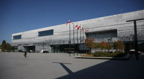 Nowoczesne muzeum historii Polski otwarcie. Flagi biało-czerwone powiewają przed budynkiem.