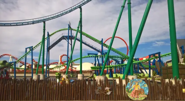 Tor RMF Dragon Roller Coaster, z zielonymi i niebieskimi torami, zapowiada ekscytującą jazdę i maksymalną prędkość.
