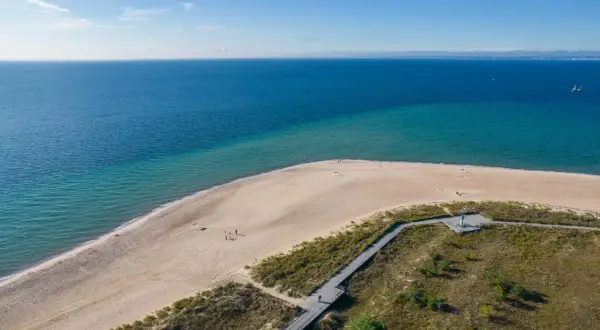 Piękna plaża i morze na Helu. Warto zobaczyć to miejsce, gdzie drewniana kładka prowadzi przez wydmy do piaszczystego brzegu.