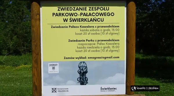 Tablica informacyjna o zwiedzaniu zespołu parkowo-pałacowego w Świerklańcu. Informacje o zwiedzaniu pałacu i parku z przewodnikiem, kosztach i godzinach.