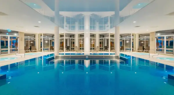 Wnętrze aquaparku Crystal Mountain z basenem, jacuzzi i leżakami.
