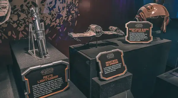 Miecz świetlny Rey, hełm pilota A-winga i pojazd Resistance Ski Speeder z wystawy Star Wars Galaxy's Edge.