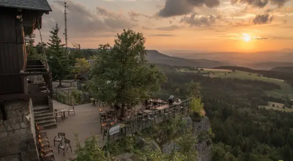 Widok z tarasu restauracji na malowniczą kotlinę kłodzką o zachodzie słońca.