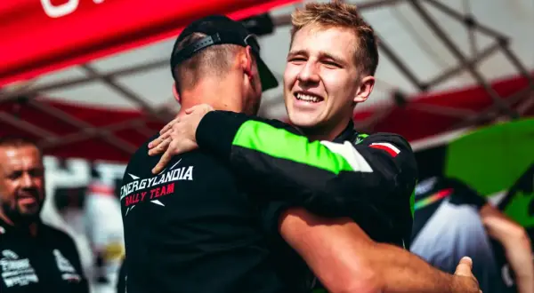 Eryk Goczał z Energylandia Rally Team świętuje zwycięstwo, przytulając kolegę z zespołu.