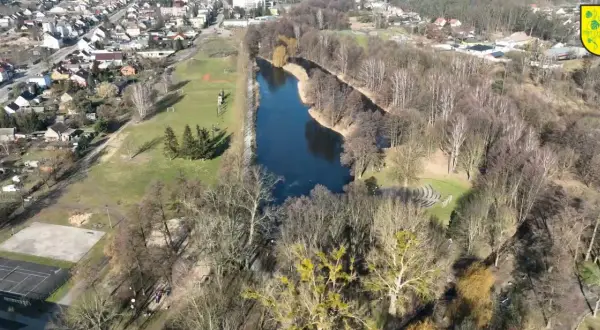 Widok z lotu ptaka na park drogowskazów w Witnicy. Jezioro, boisko, korty tenisowe i zabudowania mieszkalne.