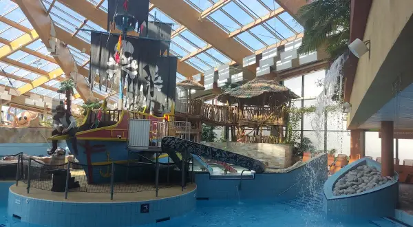 Wesoły aquapark w Czechach z pirackim statkiem, zjeżdżalniami i wodospadem. Idealne miejsce na rodzinną zabawę.