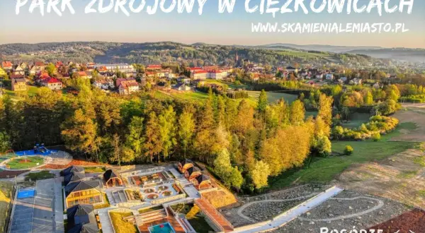 Park Zdrojowy w Ciężkowicach oferuje liczne atrakcje: plac zabaw, basen, sauny i ścieżki spacerowe. Widok z góry na malownicze Pogórze.