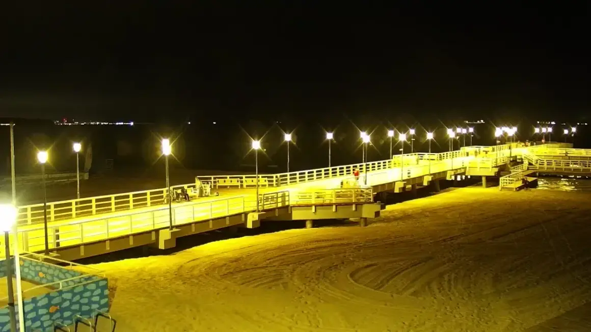 Nocne Jelitkowo: oświetlony molo, plaża i morze. Atrakcje turystyczne w blasku latarni.