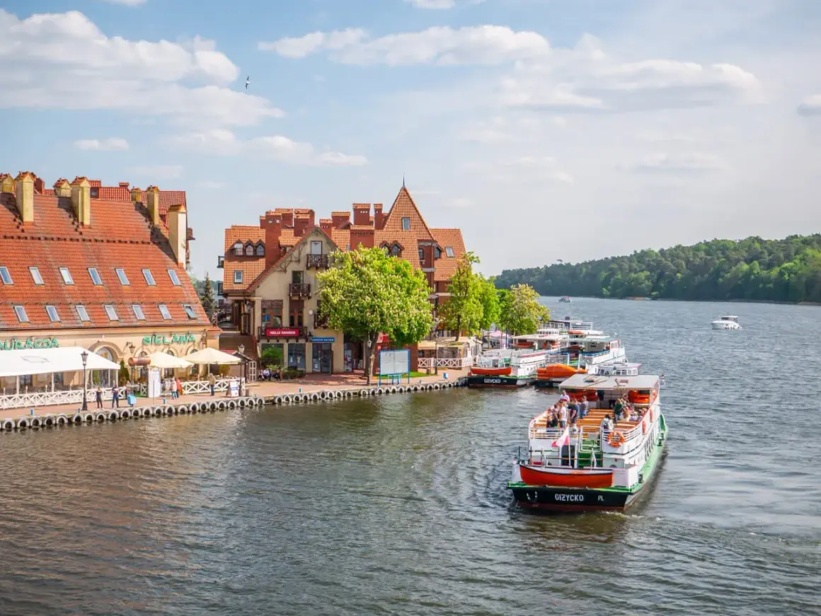 Port w Giżycku, cumujące statki i urokliwe kamieniczki. Wspaniałe gizycko atrakcje dla każdego.