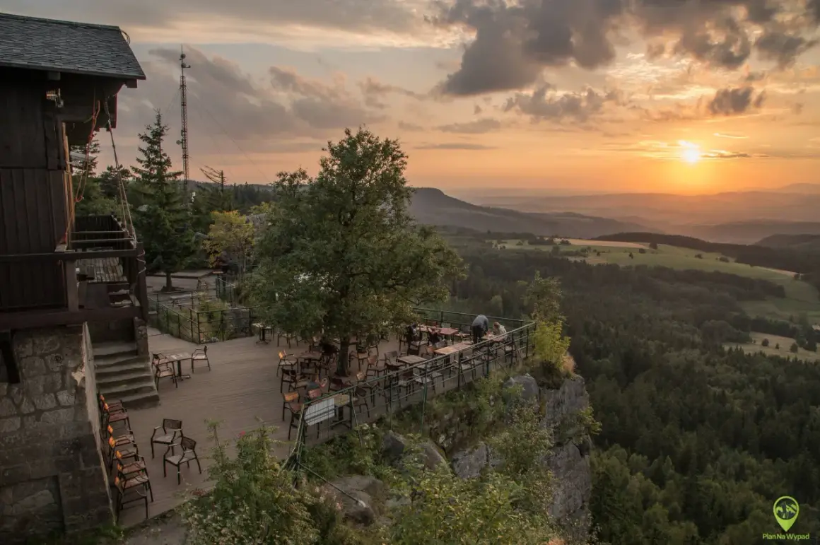 Widok z tarasu restauracji na malowniczą kotlinę kłodzką o zachodzie słońca.
