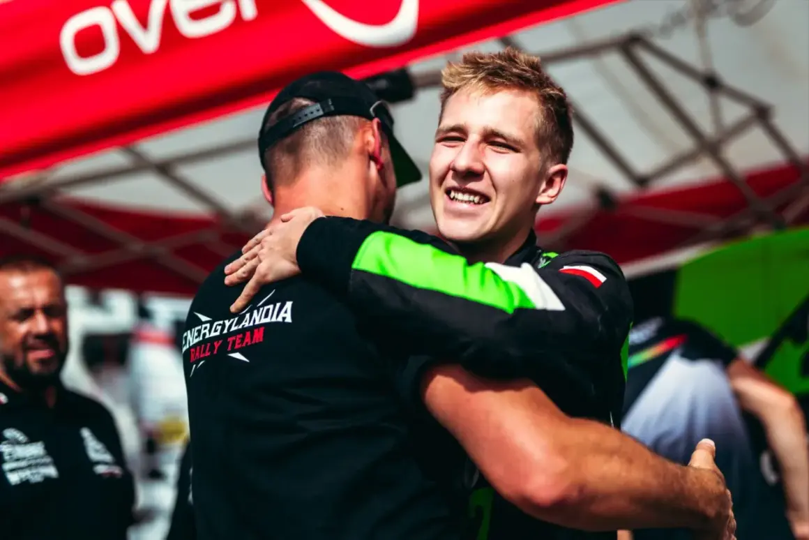 Eryk Goczał z Energylandia Rally Team świętuje zwycięstwo, przytulając kolegę z zespołu.