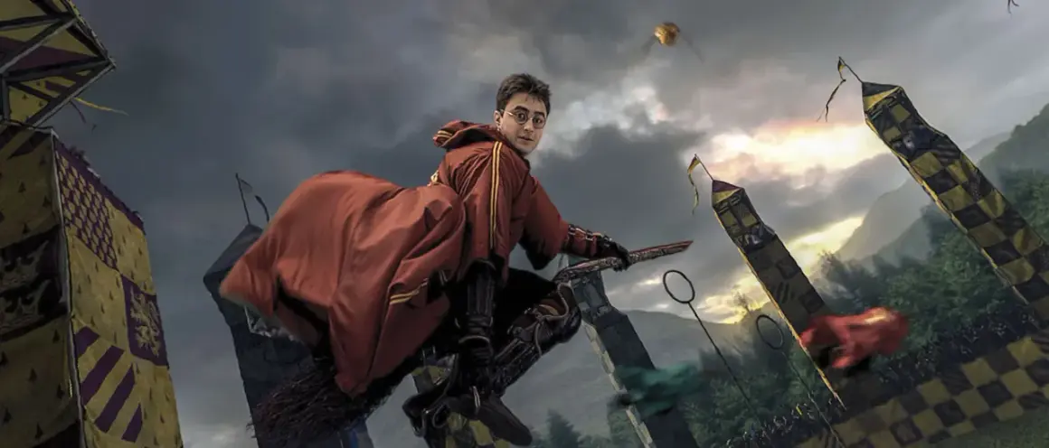 Harry Potter na miotle, w czerwonym szacie, ściga Złoty Znicz podczas meczu quidditcha. To scena z filmu "Harry Potter i Zakazana Podróż".