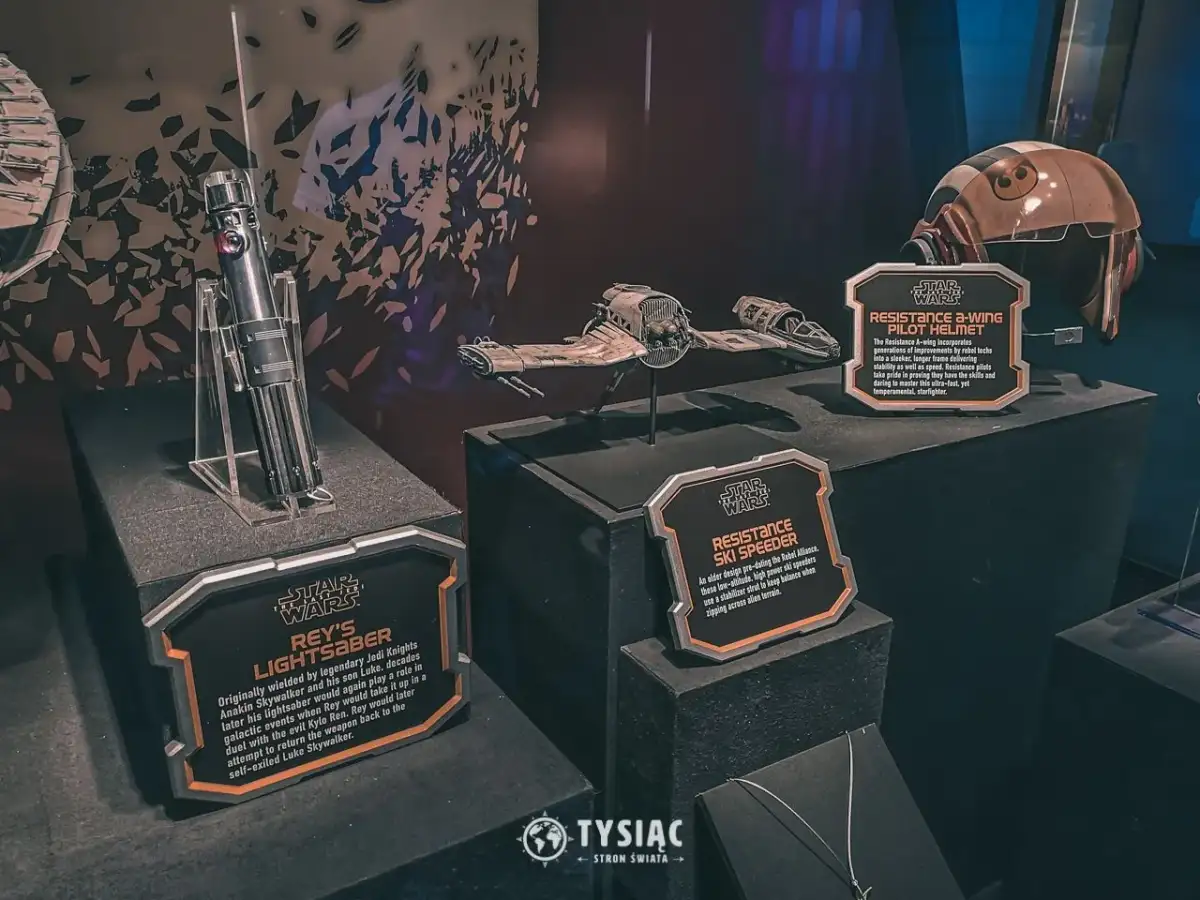 Miecz świetlny Rey, hełm pilota A-winga i pojazd Resistance Ski Speeder z wystawy Star Wars Galaxy's Edge.
