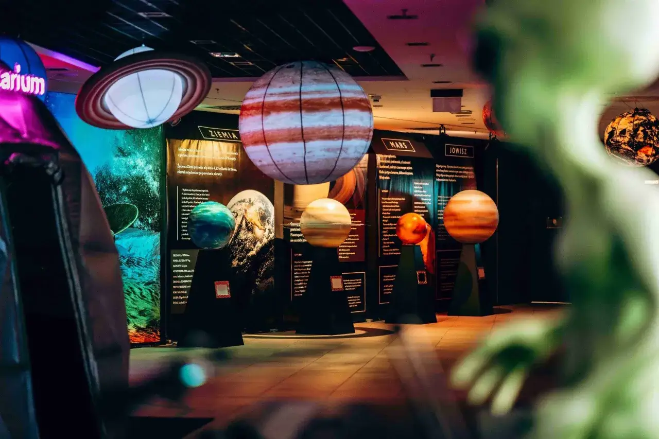 Modele planet w kosmo parku. Widać Ziemię, Marsa i Jowisza, a także Saturna wiszącego na górze.